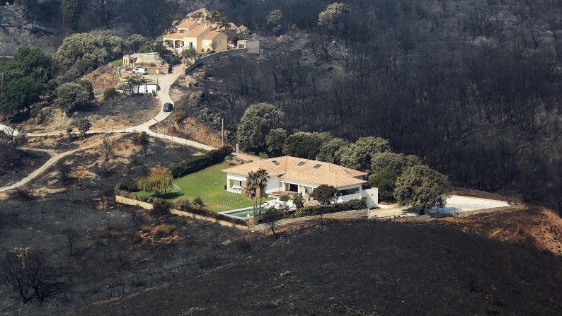 Houses are surrounded by scorched land near Biguglia, France, on the island of Corsica, on July 25.