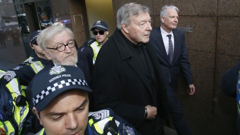 Cardinal Pell (C) walks with a heavy police guard from his barristers Robert Richter office to the Melbourne Magistrates' Court on July 26.