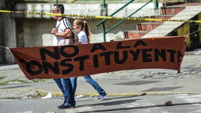 People walk past a banner placed by anti-government activists against President Nicolas Maduro's Constituent Assembly, in Caracas' Petare neighbourhood on July 26, 2017.
Venezuelans began blocking off deserted streets Wednesday as the opposition launched a 48-hour general strike aimed at thwarting embattled President Nicolas Maduro's controversial plans to rewrite the country's constitution. / AFP PHOTO / Ronaldo SCHEMIDT        (Photo credit should read RONALDO SCHEMIDT/AFP/Getty Images)