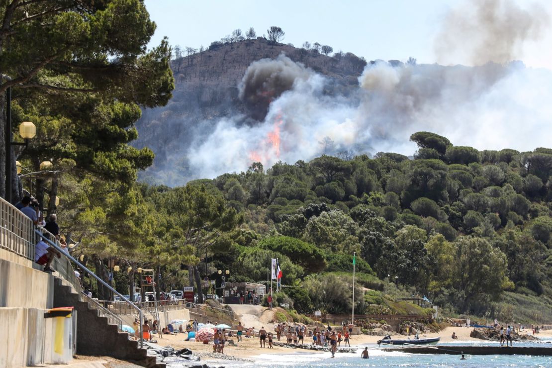 Beachgoers in La Croix-Valmer, near Saint-Tropez, watch as the fire spreads.