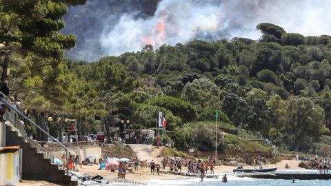 Beachgoers in La Croix-Valmer, near Saint-Tropez, watch as the fire spreads.