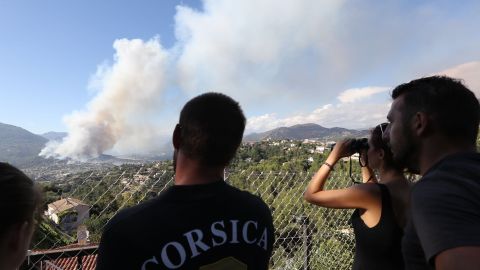 People watch smoke billow over Carros, southeastern France.