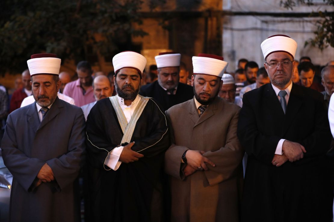 Sheikh Omar Kiswani (2-L), Al-Aqsa director, and other clergymen join as Palestinian Muslim worshippers pray outside Jerusalem's Old City.