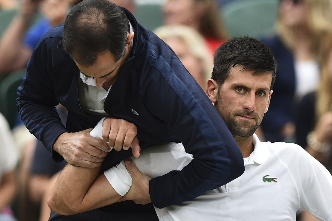 Djokovic receives medical attention on court during his fourth-round match against Adrian Mannarino at Wimbledon.