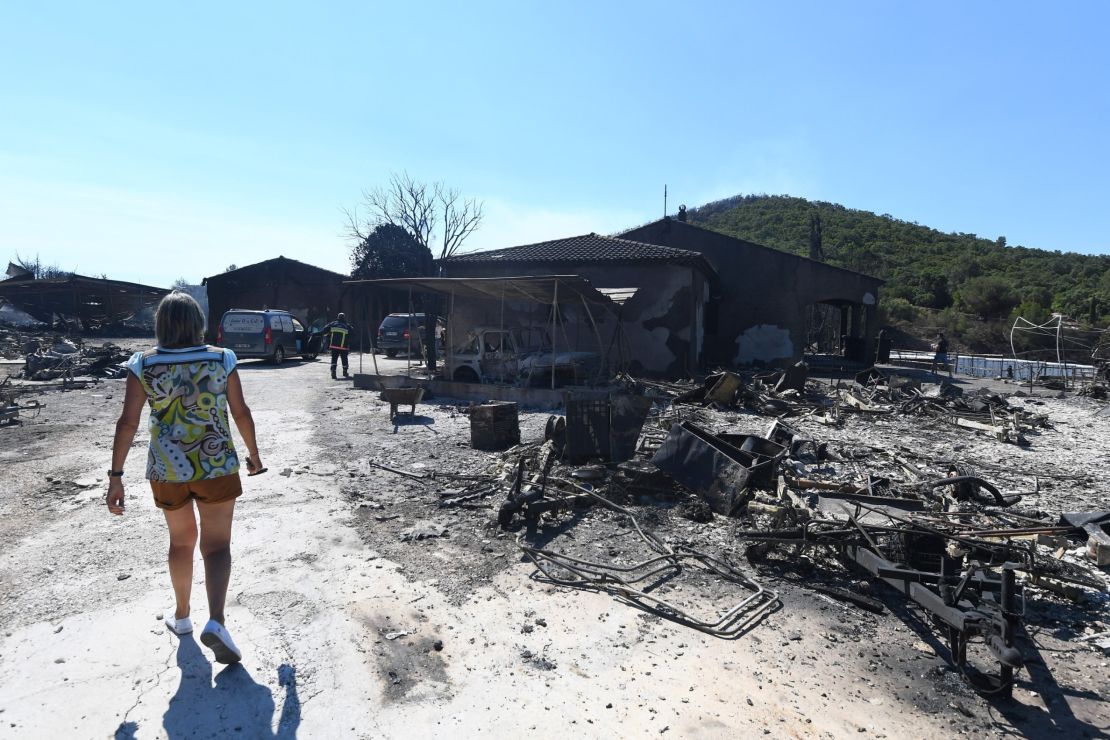A woman inspects the damage following a fire in Bormes-les-Mimosas.
