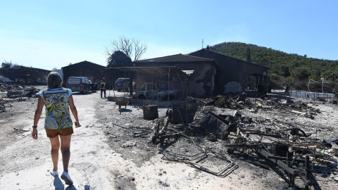 A woman inspects the damage following a fire in Bormes-les-Mimosas.
