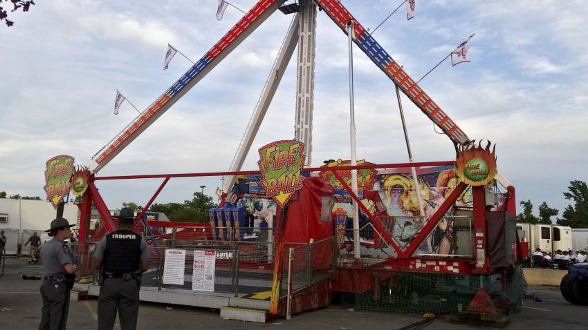 Authorities stand near the Fire Ball amusement ride after the ride malfunctioned injuring several at the Ohio State Fair, Wednesday, July 26, 2017, in Columbus, Ohio. Some of the victims were thrown from the ride when it malfunctioned Wednesday night, said Columbus Battalion Chief Steve Martin. (Jim Woods/The Columbus Dispatch via AP)