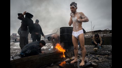 Migrants bathe outside near a makeshift shelter in an abandoned warehouse in Subotica, Serbia, in January 2017.