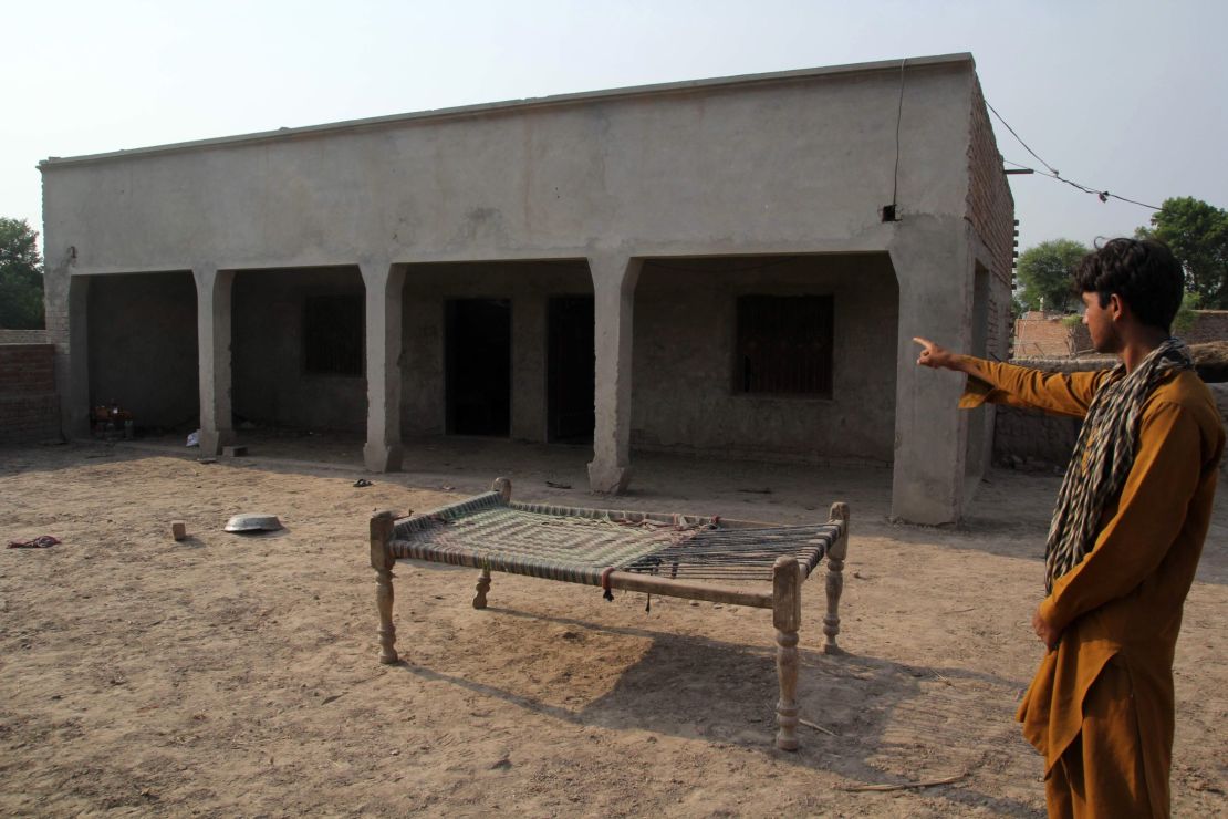 A Pakistani villager points to a house where a teenage girl was raped in Muzaffarabad, taken on July 26.