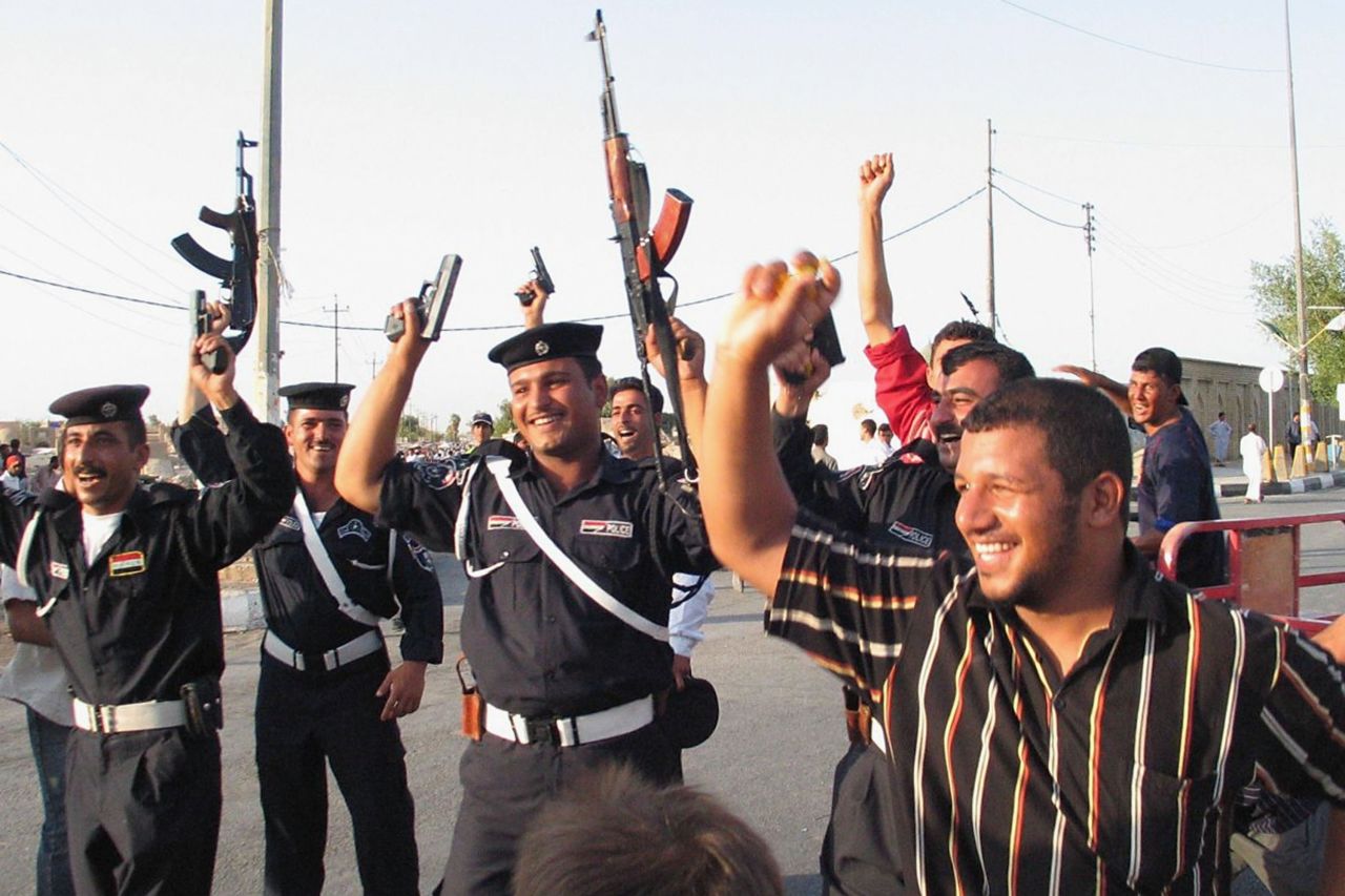 Many fired their weapons in the air in celebration, including these policemen in the Shiite city of Najaf south of Baghdad.