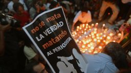 Colleagues, relatives and friends of murdered journalists place candles and pictures in an altar erected at the Independence Angel monument in Mexico City on May 5, 2012 during a vigil to protest against violence towards the press. On Thursday Mexican security forces found the dismembered bodies of missing news photographers Guillermo Luna Varela and Gabriel Huge and two other people in bags dumped in a canal in the eastern state of Veracruz. The bodies of the photographers, who worked for the Veracruz news photo agency, also showed signs of torture. The postre reads "The Truth is Not Killed by Killing The Journalist".   AFP PHOTO/Yuri CORTEZ        (Photo credit should read YURI CORTEZ/AFP/GettyImages)