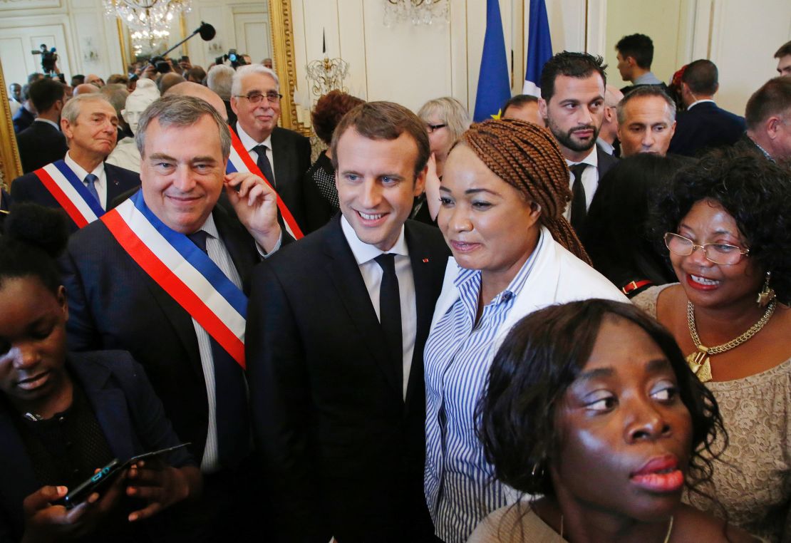 Mayor of Orleans Olivier Carre (L) and French President Emmanuel Macron (C) pose for a group photo with people who received French citizenship.