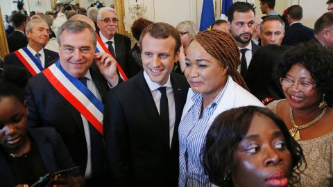 Mayor of Orleans Olivier Carre (L) and French President Emmanuel Macron (C) pose for a group photo with people who received French citizenship.