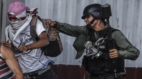 A national guard member grabs an anti-government activist during clashes Thursday in Caracas.