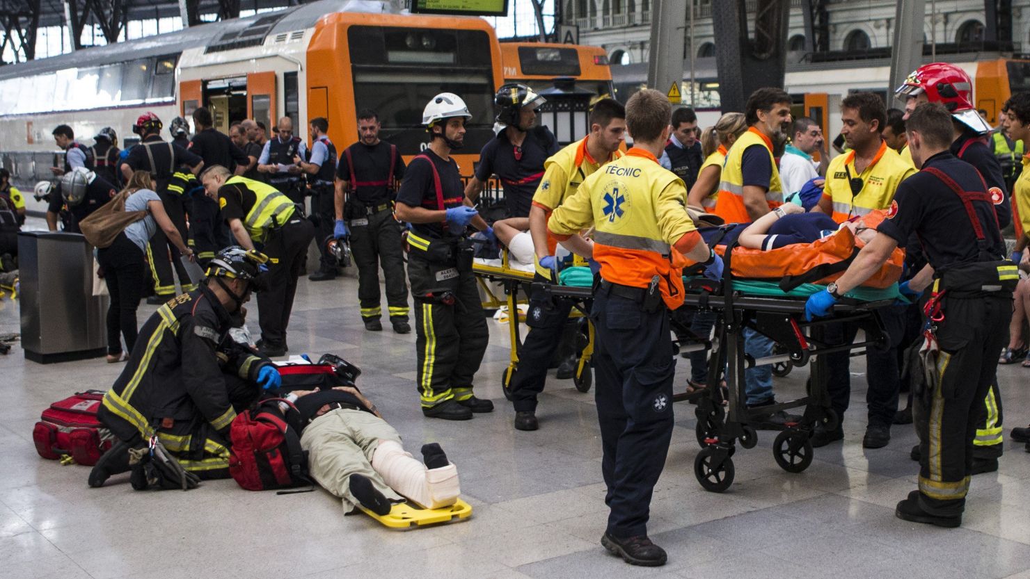 Spanish firefighters and paramedics treat injured people.