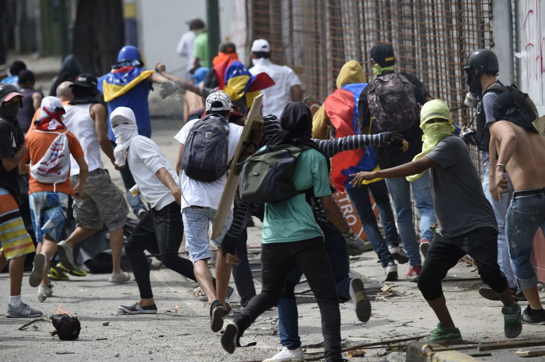 Anti-government activists clash with troops in Caracas on Thursday, the second day of a general strike.