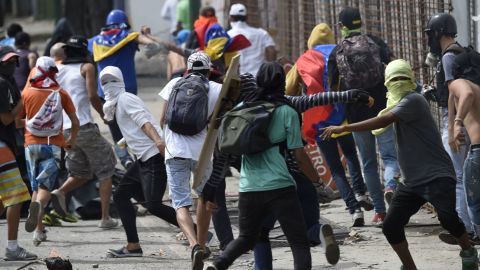 Anti-government activists clash with troops in Caracas on Thursday, the second day of a general strike.