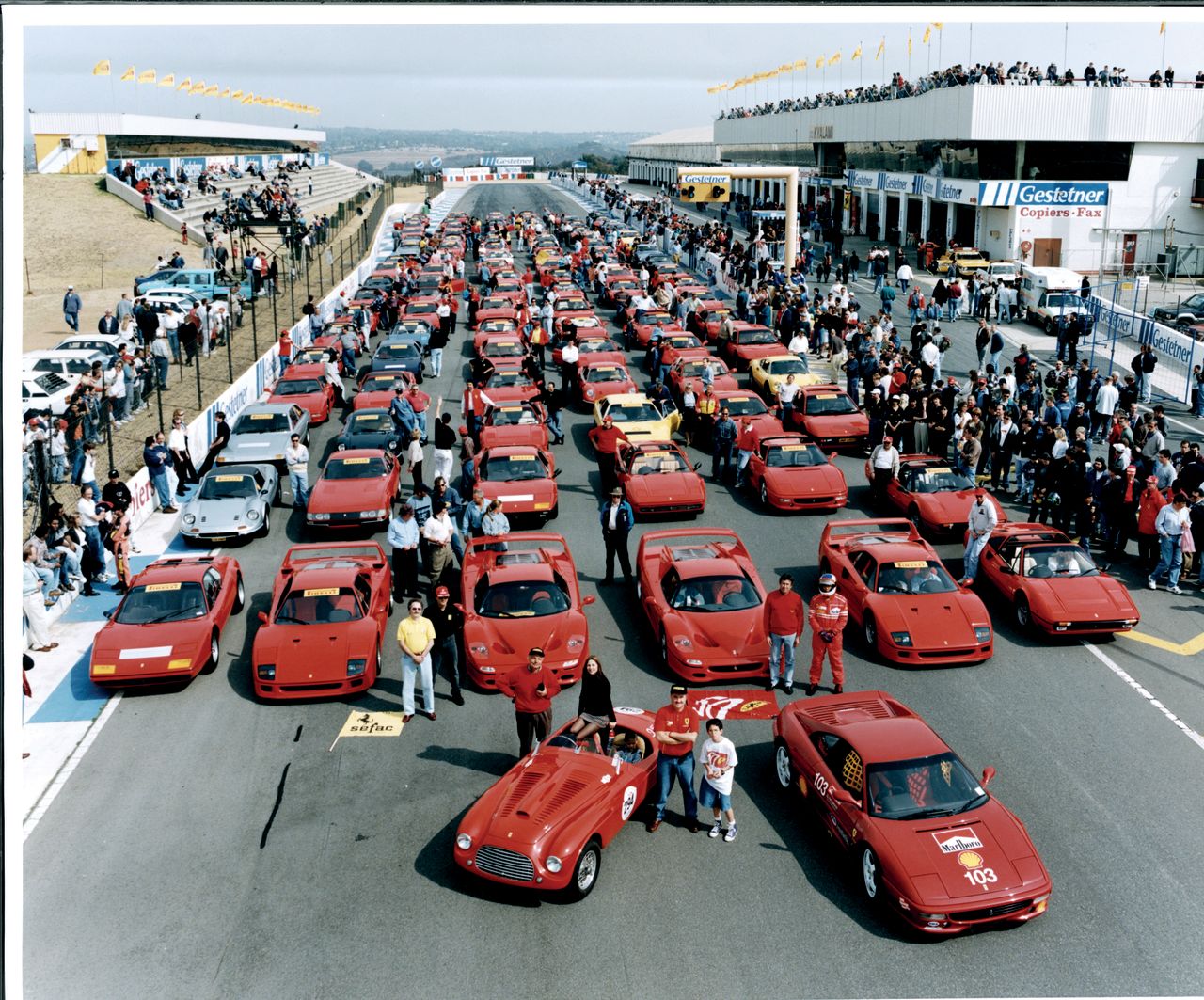As the turn of the millennium approached, what had started with Enzo Ferrari facilitating gentlemen racing their cars had evolved into a global phenomenon. Here, racing enthusiasts gather at South Africa's Kyalami Circuit to celebrate Ferrari 50th Anniversary.