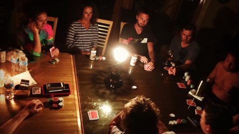 Friends play poker by candlelight after a power outage on Hatteras Island.