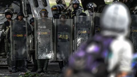 National guard troops in riot gear stand behind shields during a protest Friday in Caracas. 
