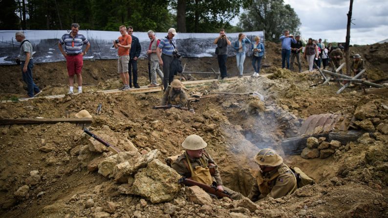 Visitors and tourists walk among actors as they recreate scenes from the Battle of Passchendaele on July 30 in the Ypres Salient battlefields area of Belgium. Dignitaries and descendants of those who fought gathered to mark the centenary of the Third Battle of Ypres.