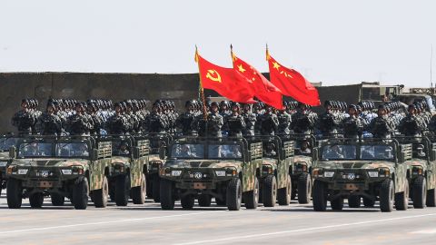 Chinese soldiers carry the flags of the Communist Party and the People's Liberation Army during a military parade in China's northern Inner Mongolia region on July 30, 2017.