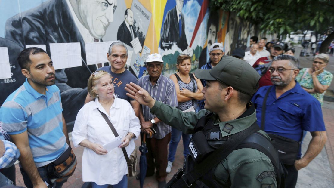 A Bolivarian National Guard officer instructs voters Sunday outside a polling station in Caracas. 