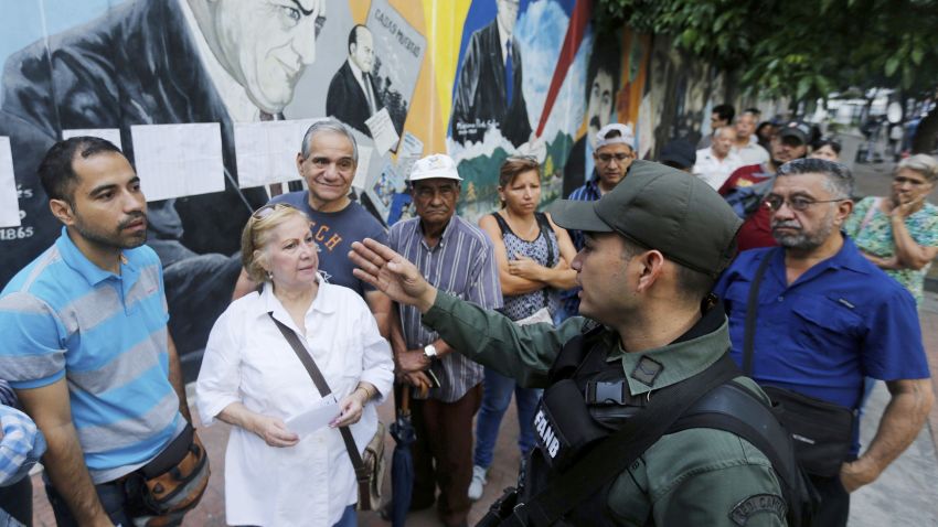 Voters receive instructions by a Venezuelan Bolivarian National Guard officer outside a polling station during the election for a constitutional assembly in Caracas, Venezuela, Sunday, July 30, 2017.