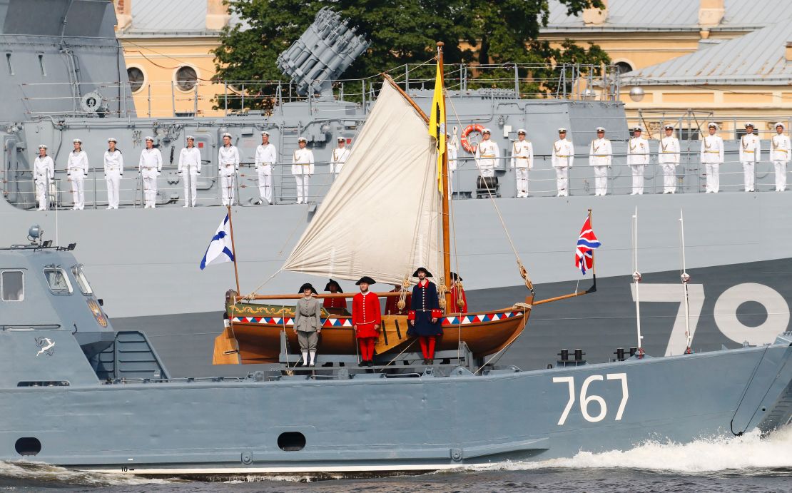 Russian sailors stand in attention on a military vessel carrying a replica of a boat of Peter The Great during a naval parade in St. Petersburg.