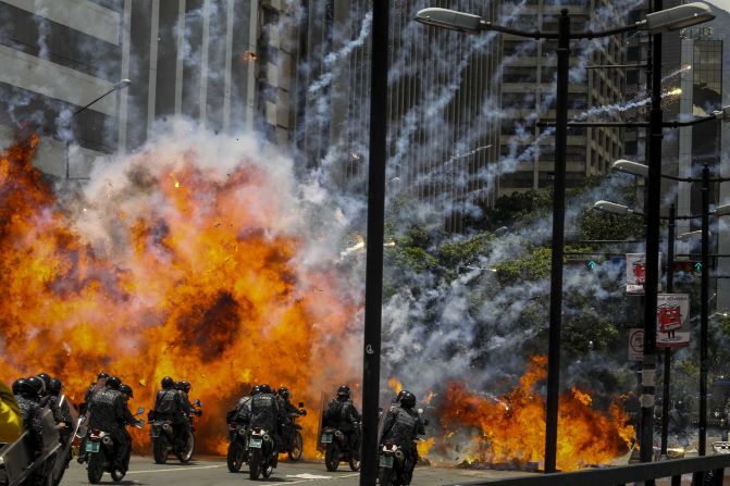 Members of Venezuela's national police are caught in an explosion as they ride motorcycles near Altamira Square in Caracas on July 30. Venezuela <a href="index.php?page=&url=http%3A%2F%2Fwww.cnn.com%2F2017%2F05%2F09%2Famericas%2Fvenezuela-violin-protester%2F" target="_blank">has seen widespread unrest</a> since March 29, when the Supreme Court dissolved Parliament and transferred all legislative powers to itself. The decision was later reversed, but protests have continued across the country, which is also in the midst of an economic crisis.
