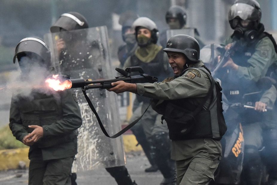 A member of the National Guard fires at protesters during clashes in Caracas on Friday, July 28. 