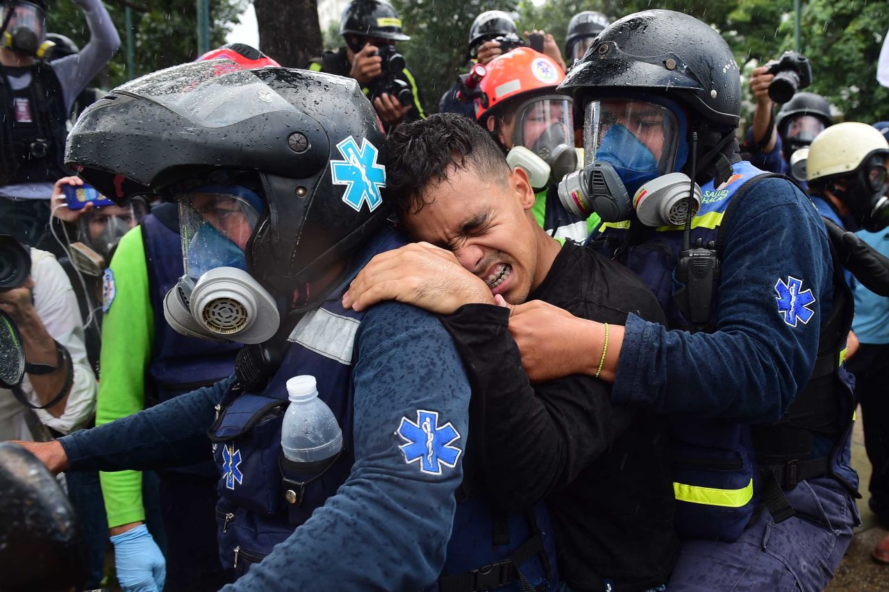 A wounded anti-government demonstrator is helped by medics during clashes with police in Caracas on July 30.