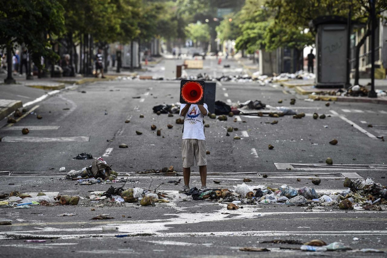 A demonstrator shouts slogans through a traffic cone during an anti-government protest in Caracas on July 30.