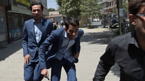 Afghan residents run at the site of a suicide blast near Iraq's embassy in Kabul on July 31.