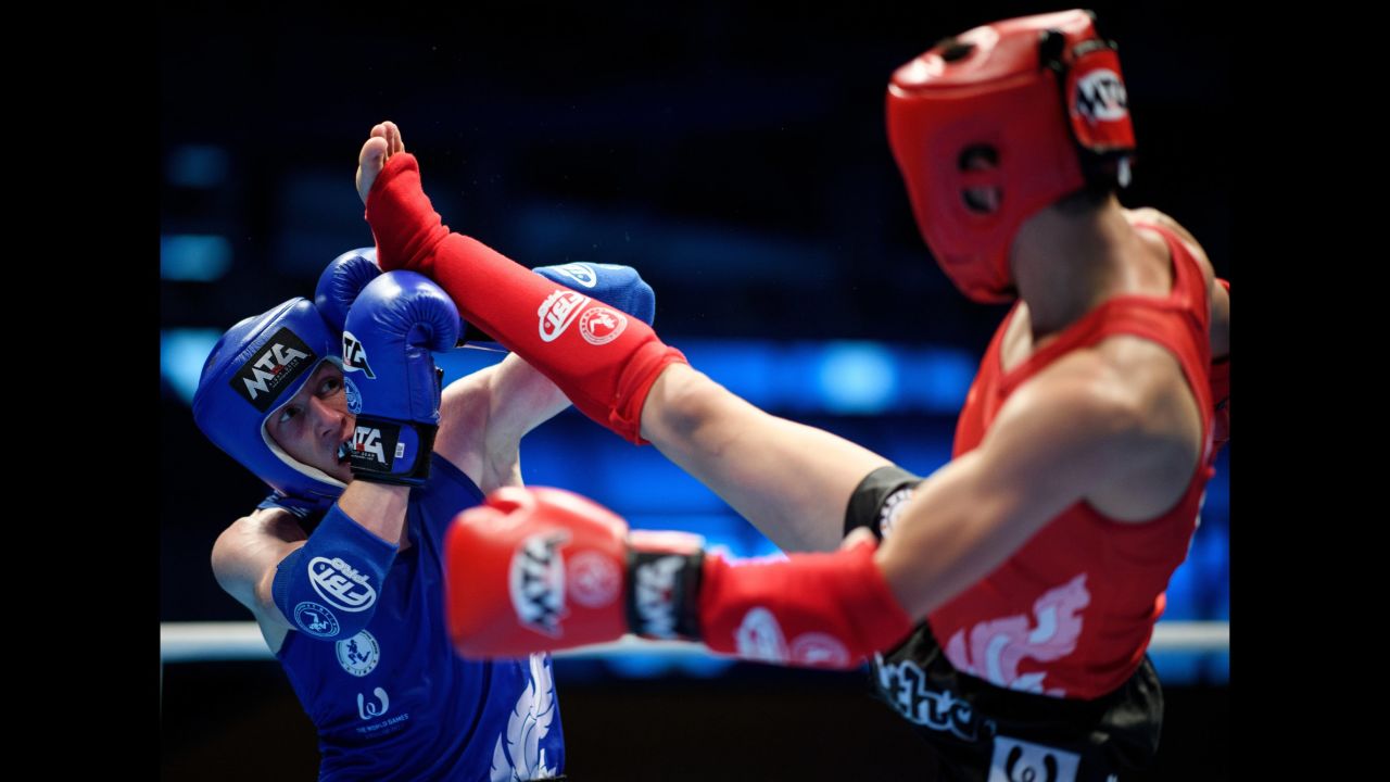 Poland's Przemyslaw Kmiecik blocks a kick from Kazakhstan's Elaman Sayasatov during a muay thai match at the World Games on Friday, July 28. Sayasatov went on to win gold in his weight class.