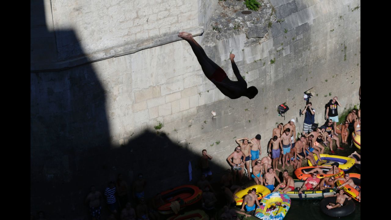 Spectators watch a diver jump from the Old Mostar Bridge in Mostar, Bosnia-Herzegovina, on Sunday, July 30. The high-diving competition in Mostar is more than 400 years old.