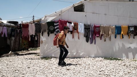 Syrian refugee Yamen, 10, passes laundry at an informal settlement in the Bekaa Valley, Lebanon.