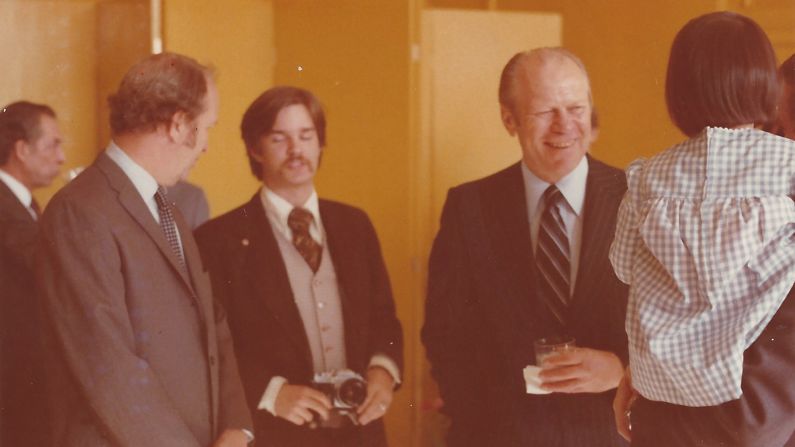 President Gerald Ford, right, visited the US Beijing Liaison Office in 1976. Booth, seen here holding a camera, was responsible for assisting the Secret Service with Ford's security on the ground. "My role was guaranteeing that no one came into his immediate area uninvited," Booth remarked. Booth's lapel pin acted as a secret signal to his fellow Secret Service special agents and White House staff that he was armed. "I probably have my Smith and Wesson  Model 19 .357 magnum attached to my belt," he explained. 