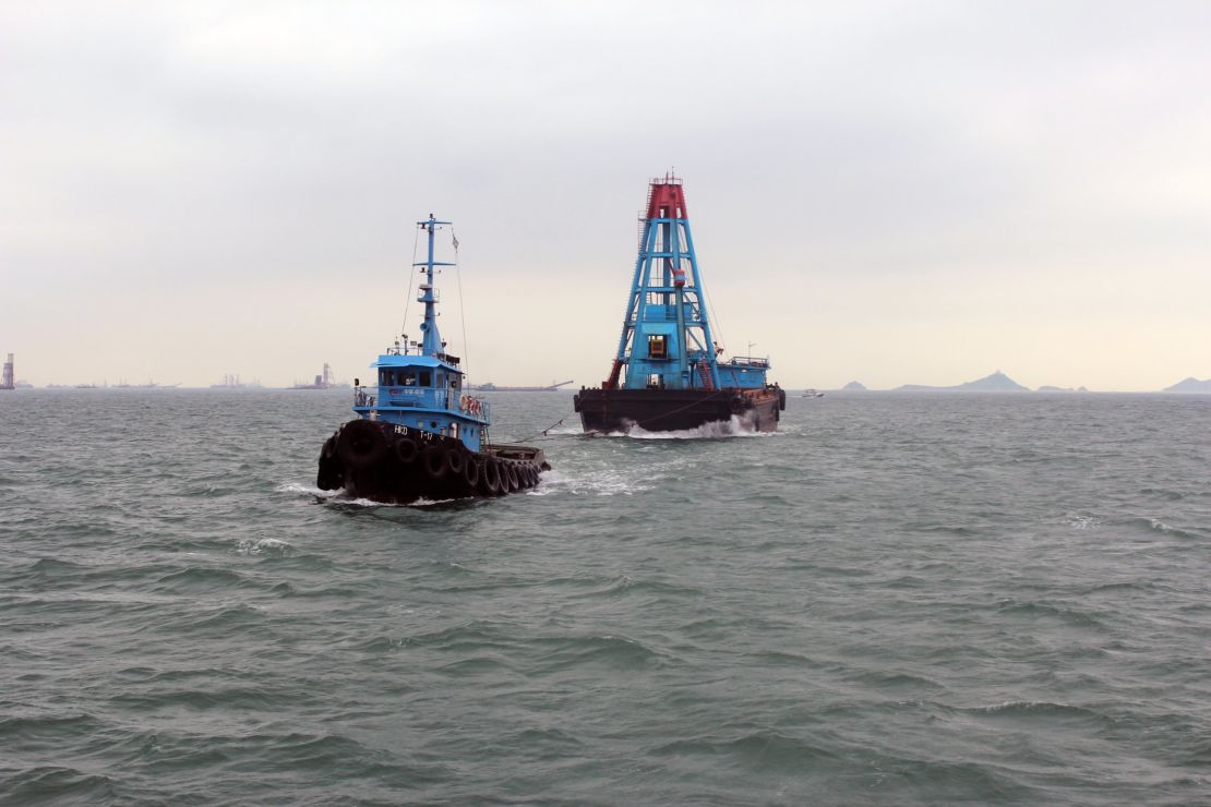 A tubboat passes by Hong Kong International Airport towards Victoria Harbor. 