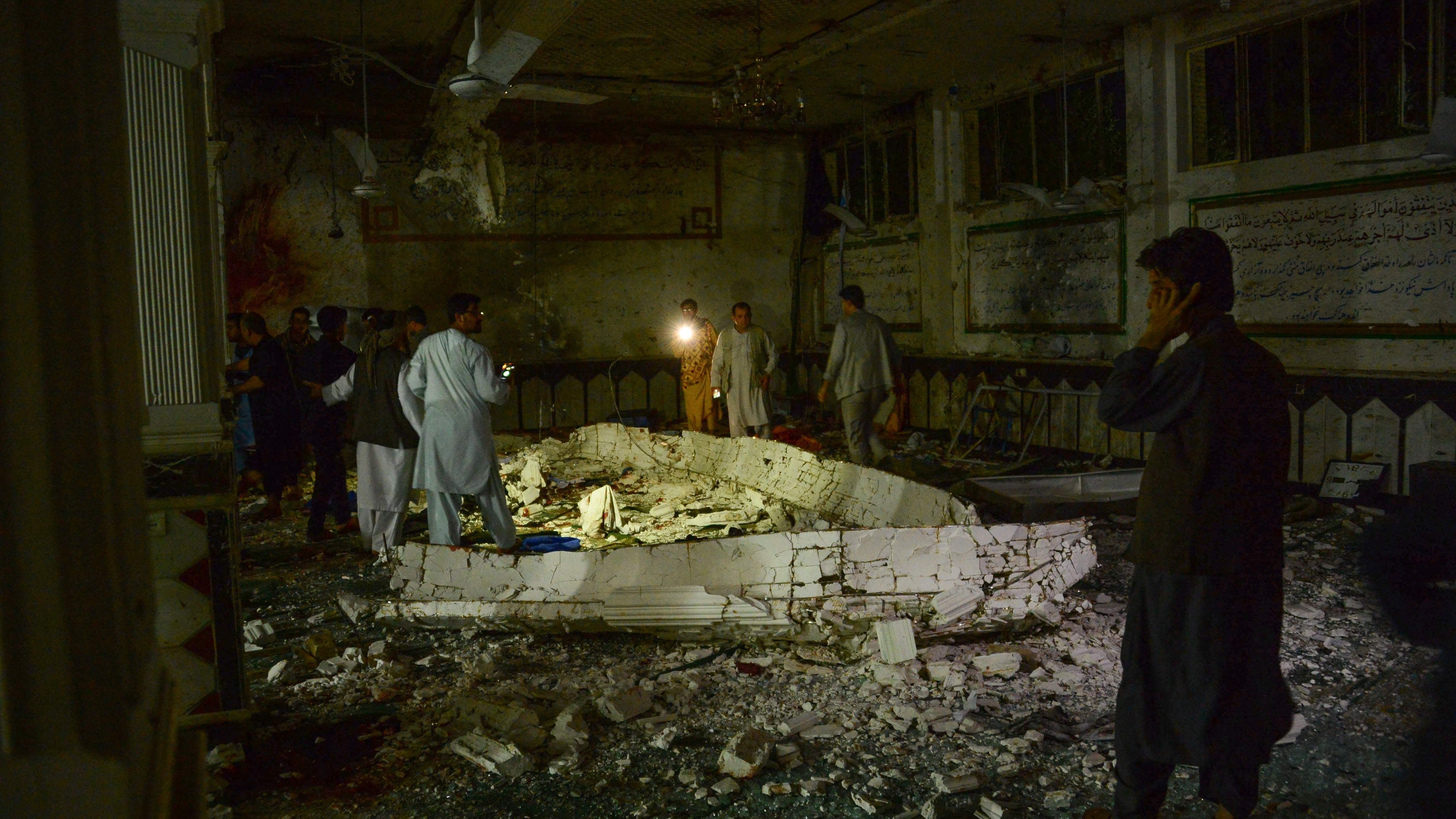 Afghan security personel inspect the site of a suicide bomb attack Tuesday at a Shiite mosque in Herat.