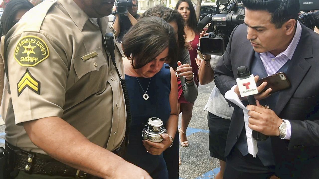 Ana Estevez carries an urn with her son's ashes.