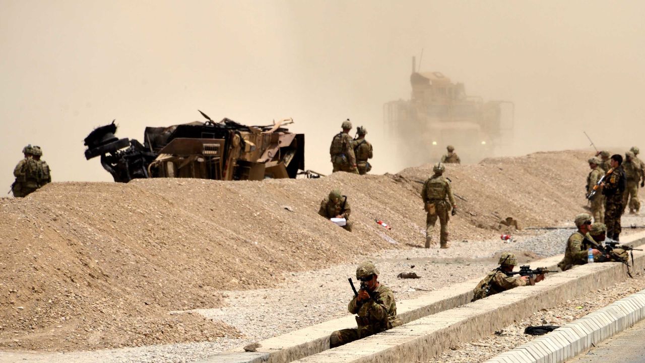 US soldiers keep watch near the wreckage of their vehicle in Kandahar on Wednesday.