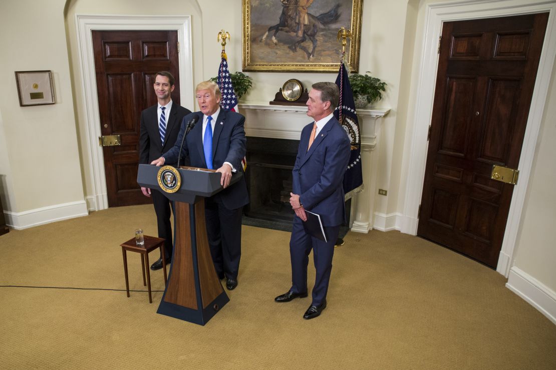 President Donald Trump makes an announcement with Sen. Tom Cotton, at left, an Arkansas Republican, and Sen. David Perdue, at right, a Georgia Republican, in the Roosevelt Room at the White House in August 2017. (Photo by Zach Gibson - Pool/Getty Images)