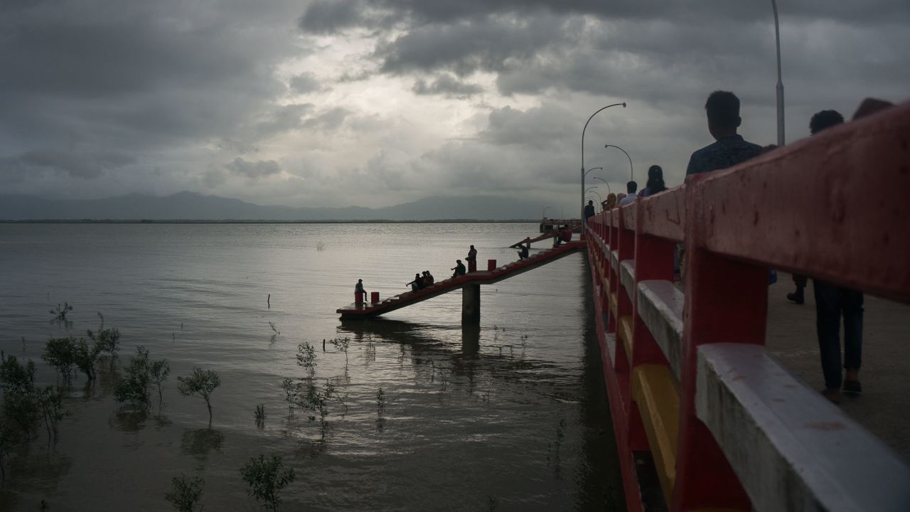 Bangladeshis take a stroll on a peer that juts out into the Naf River that divides Bangladesh and Myanmar. Every year millions of yaba methamphetamine pills are smuggled across this river feeding the nation's pill-a-day habit.
