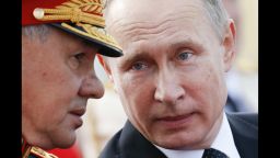 Russian President Vladimir Putin (R) speaks with Defence Minister Sergei Shoigu as they attend a ceremony for Russia's Navy Day in Saint Petersburg on July 30, 2017.
