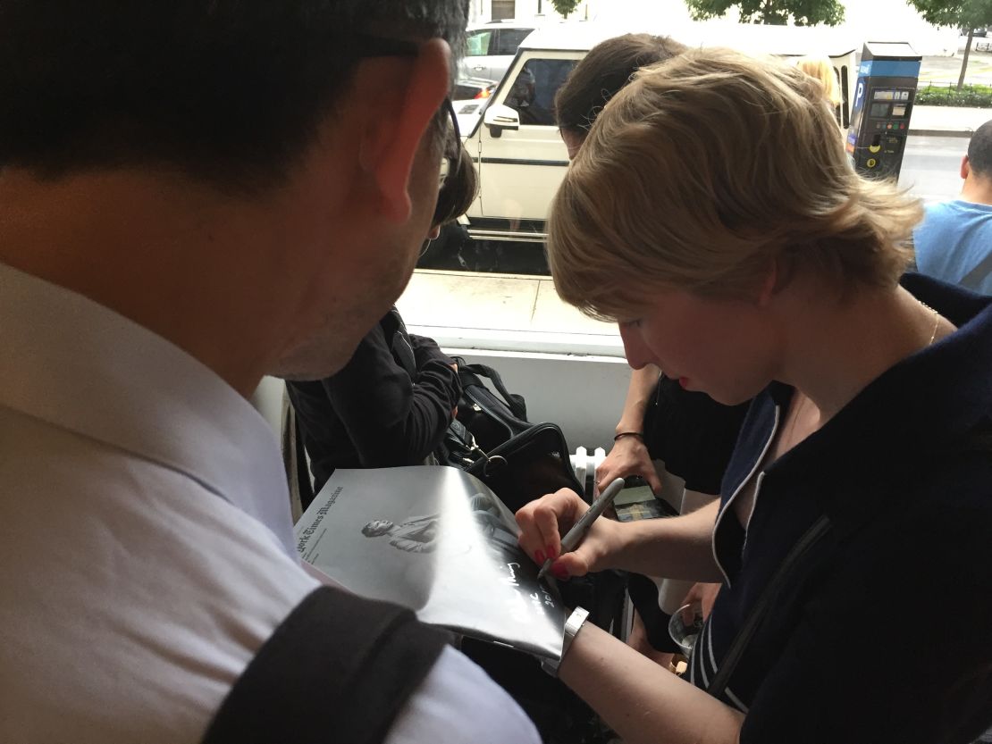 Chelsea Manning signs an autograph at her gallery opening.