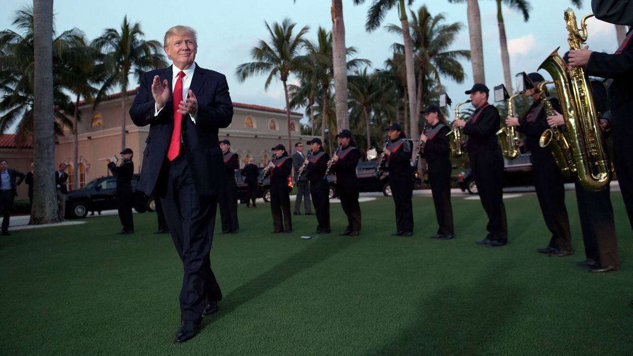 President Donald Trump listens to a high school marching band as he arrives at the Trump International Golf Club in West Palm Beach, Florida, in February 2017. He and the first lady were spending a weekend away from the White House. Here's a look at how Trump and other US presidents have escaped the pressures of the Oval Office. 