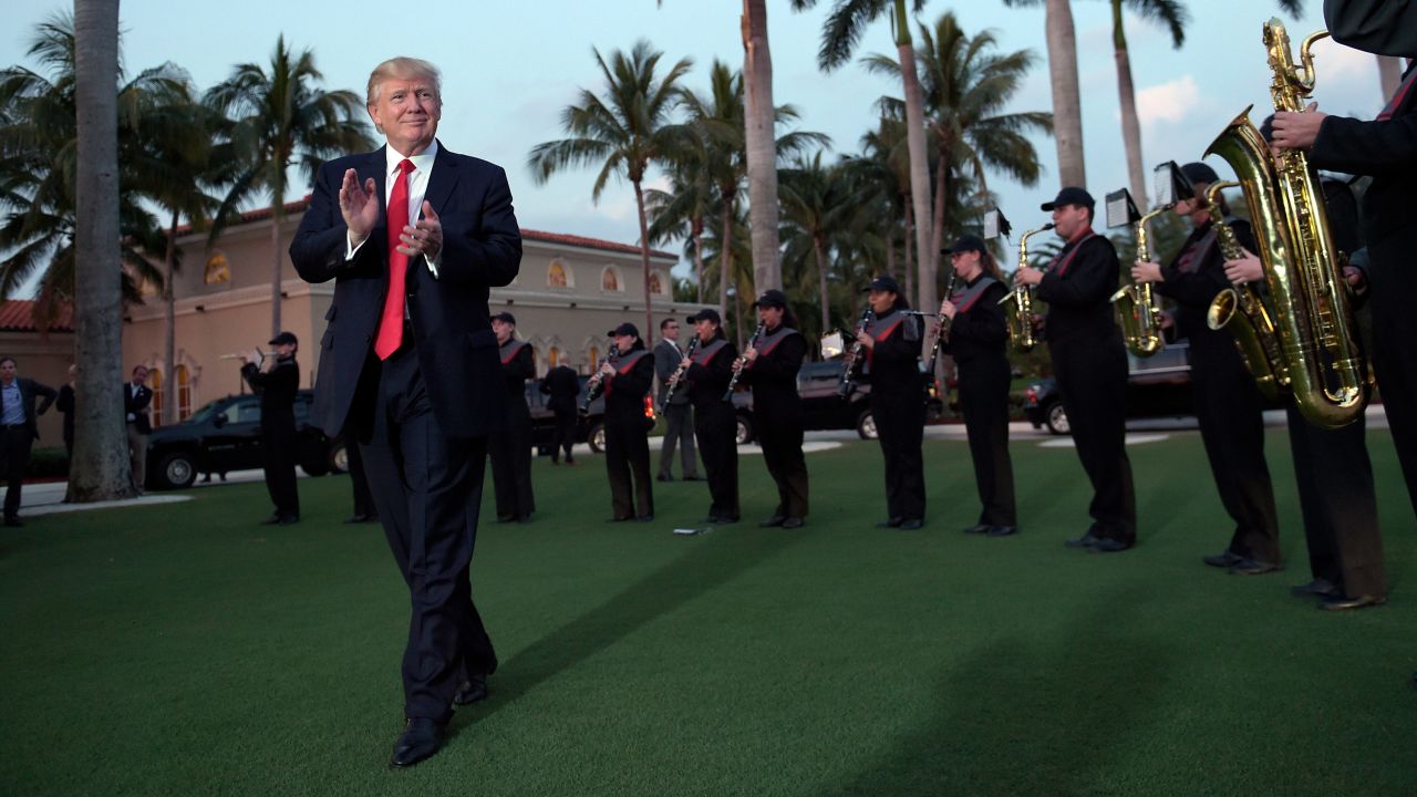 President Donald Trump listens to a high school marching band as he arrives at the Trump International Golf Club in West Palm Beach, Florida, in February 2017. He and the first lady were spending a weekend away from the White House. Here's a look at how Trump and other US presidents have escaped the pressures of the Oval Office.