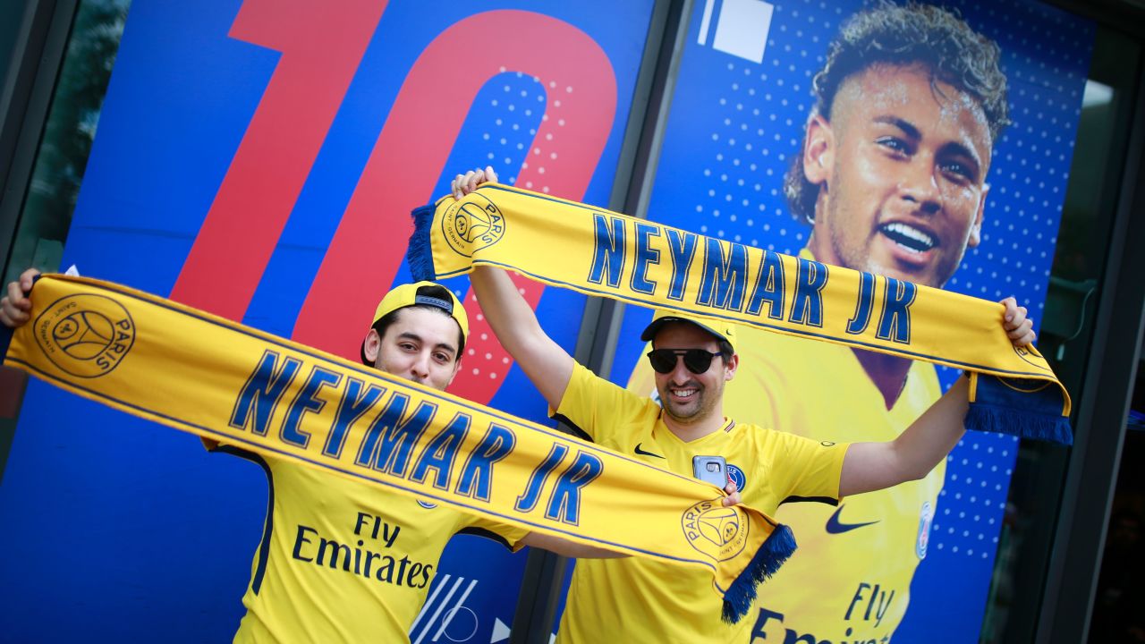 Supporters of Paris-Saint-Germain's new signing Neymar pose with scarves outside the Paris-Saint-Germain (PSG) football club store.