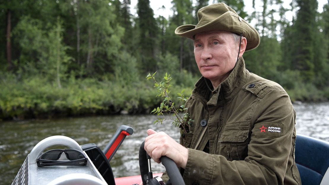 Putin guides a boat this week during his Siberian vacation.
